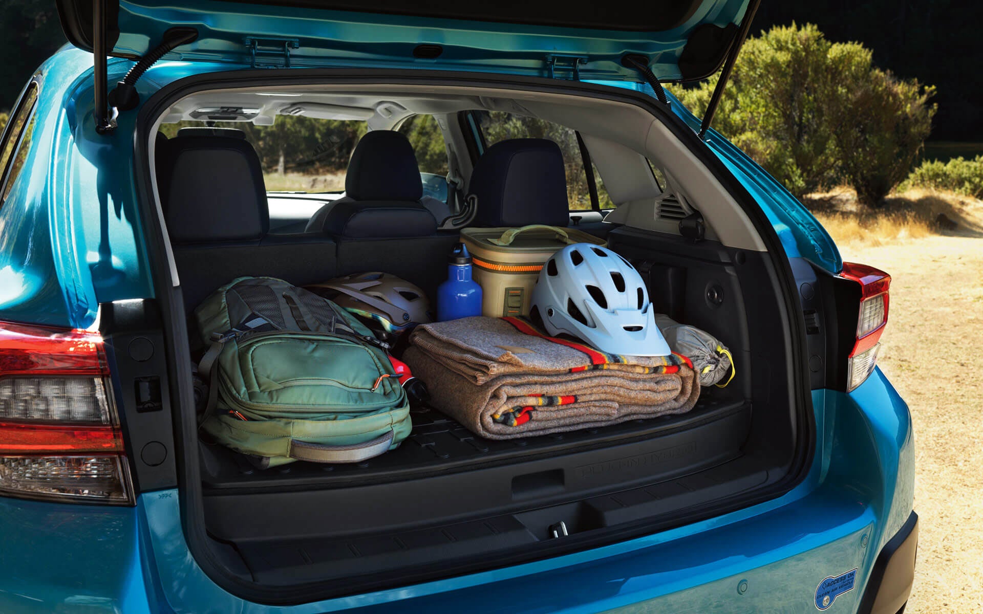 A backpack, blanket, and bike helmet in the rear cargo area of a Crosstrek Hybrid | Puente Hills Subaru in City of Industry CA