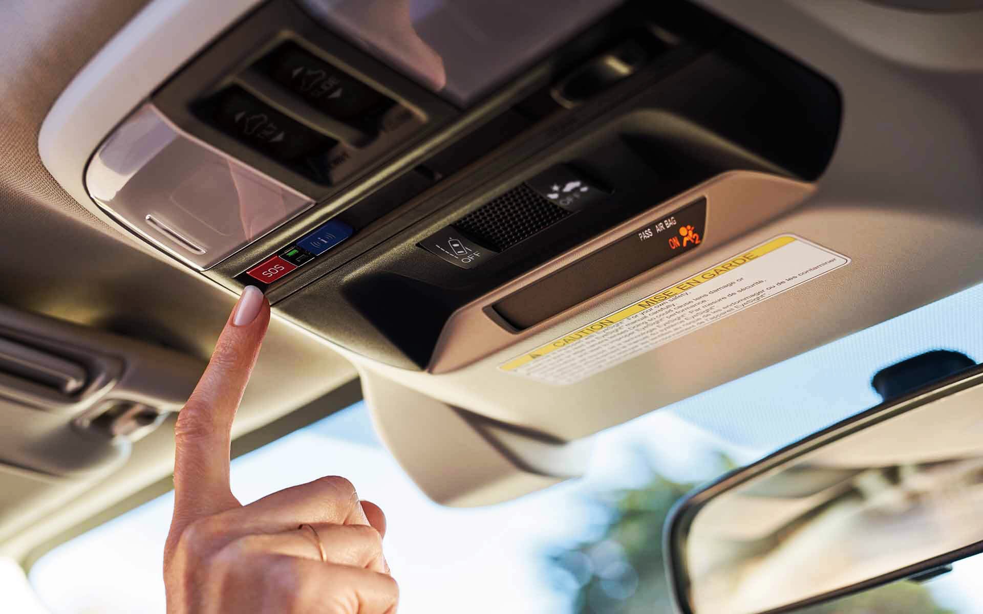 A finger pressing the Crosstrek Hybrid's SOS emergency assistance button | Puente Hills Subaru in City of Industry CA