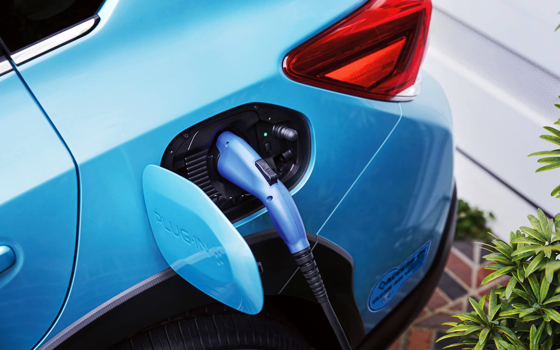 A close-up of the Subaru Crosstrek Hybrid's charging port with charging cable plugged in | Puente Hills Subaru in City of Industry CA